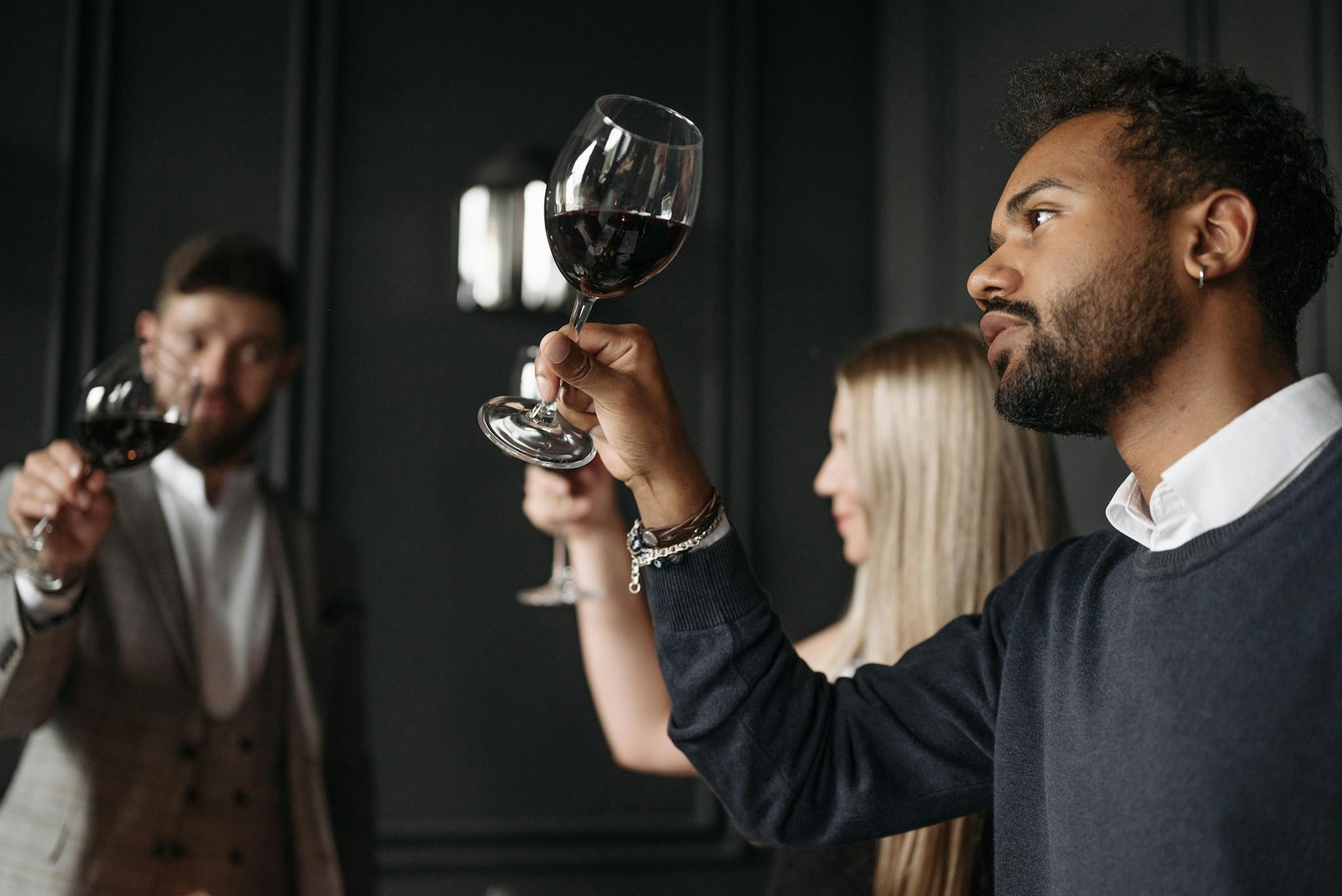 Grupa osób degustuje wino w lokalu podczas enoturystycznego spotkania