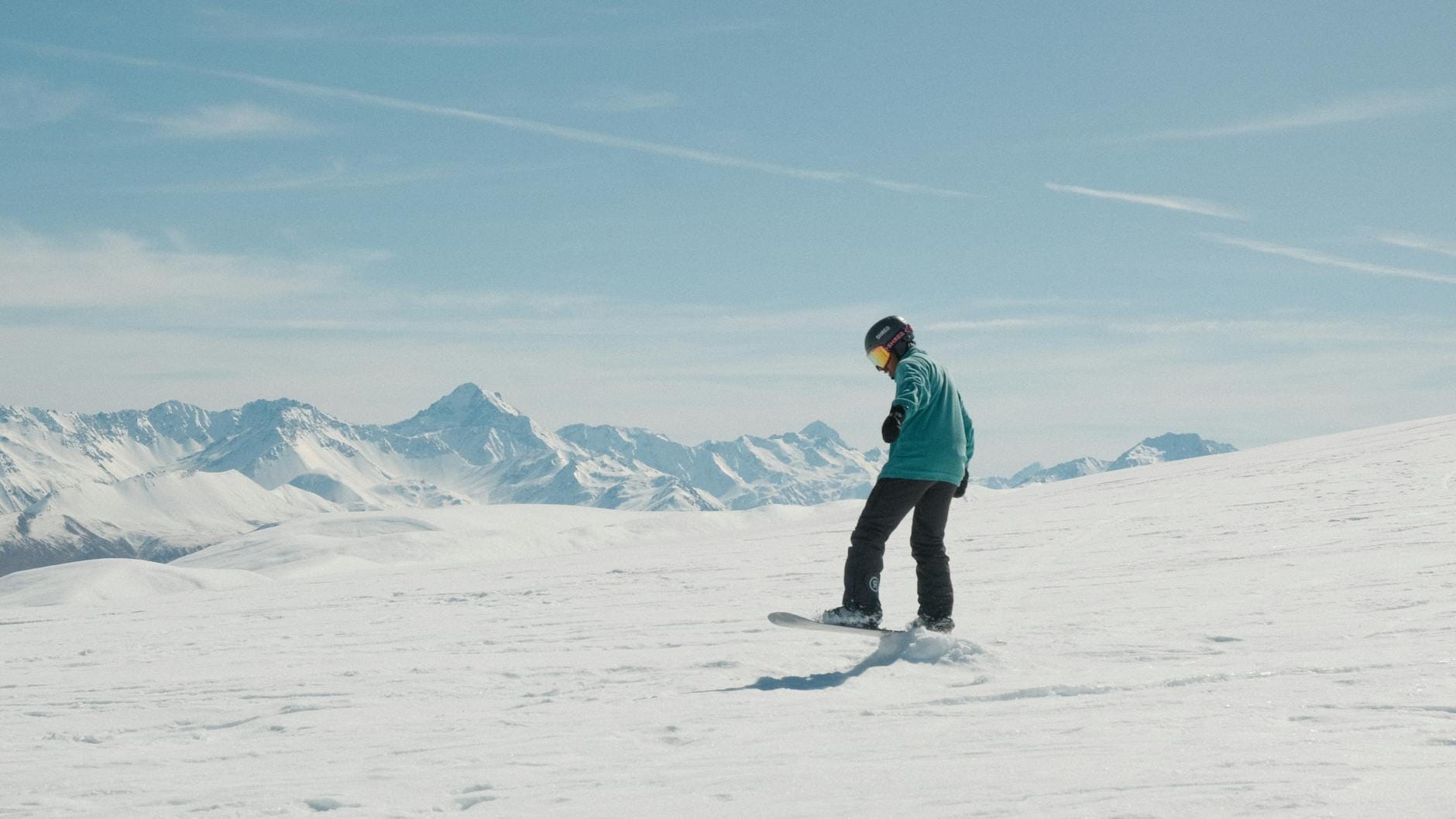 Snowboardzista na słonecznym, ośnieżonym stoku w austriackich Alpach